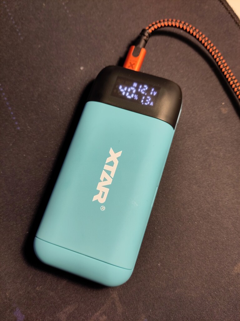 XTAR PB2S on a black mousepad, screen shots that it is charging