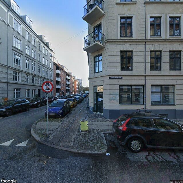 Google streetview photo of Oehlenschlaegersgade in Copenhagen. 3/4 of the space is dedicated to cars, not to humans. Both sides of the street are filled up with parked cars.