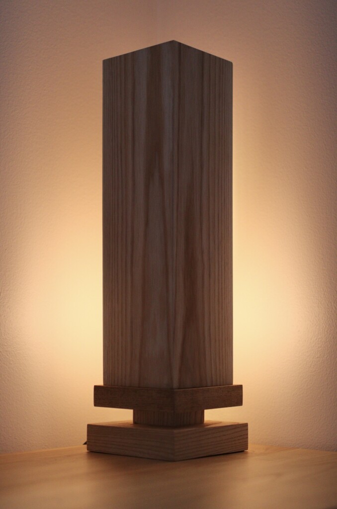 A wooden table lamp on a dresser.