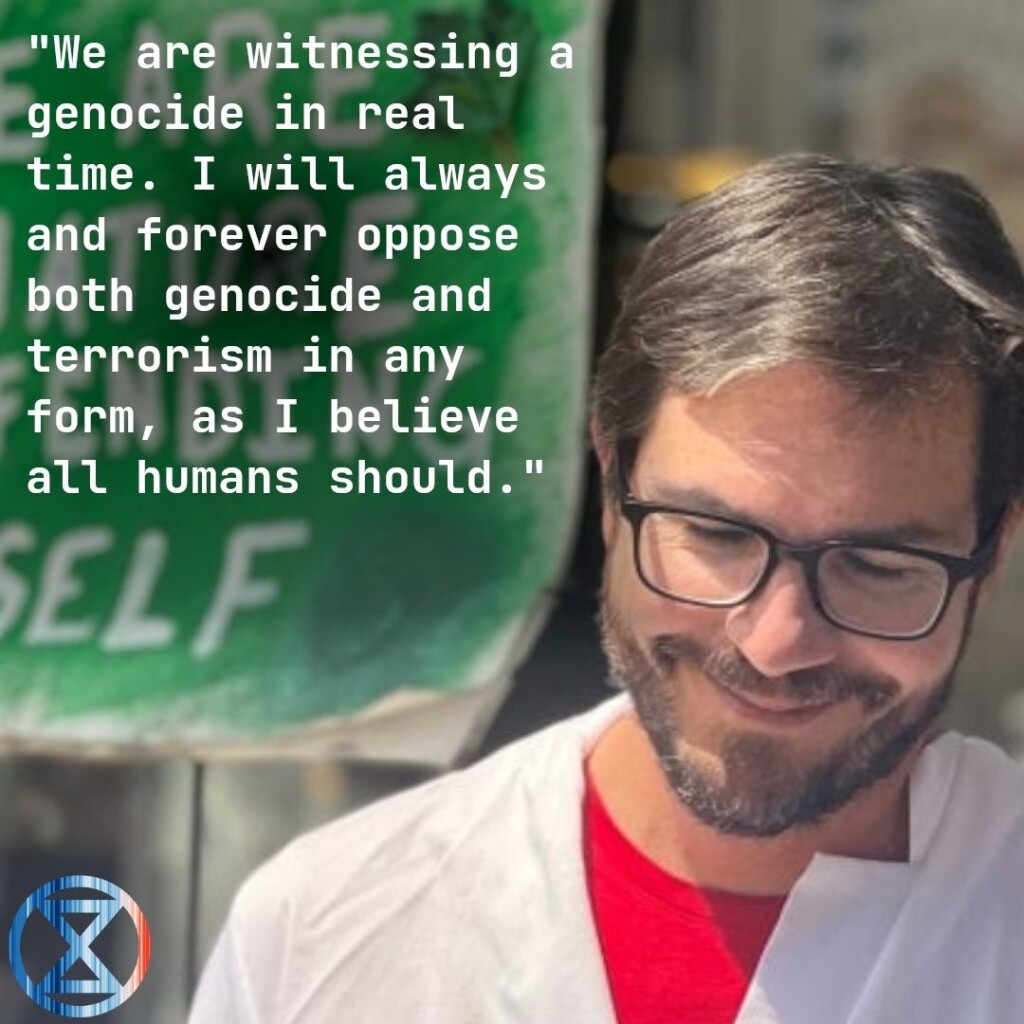 Peter Kalmus, scientist, pictured during his lock-on to Chase Bank in LA, April 2022. His quote next to him reads "We are witnessing a genocide in real time. I will always and forever oppose both genocide and terrorism in any form, as I believe all humans should".