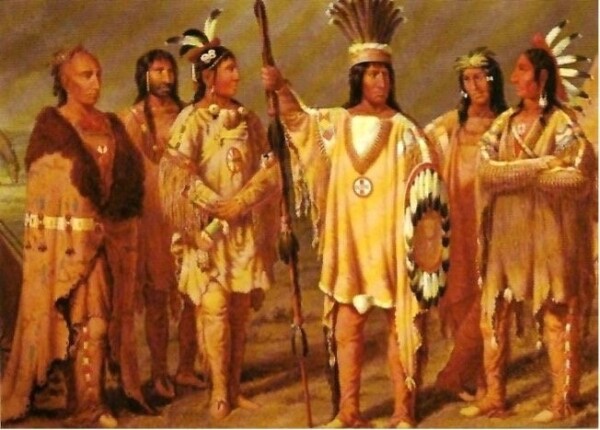 A painting depicting a group of Wendat warriors. The men are wearing hide clothing featuring beadwork, some with elaborate feather headdresses. Some have long dark hair, while others have shaved heads. Some carry weapons, such as a spear and shield. Some wear face paint. 