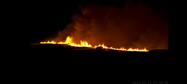 screenshot of the webcam of the freshly build vulcano in iceland with timestamp 2023-12-18 23-44-41


Its night.
The eruption looks like a line of fire out of the ground. a few smaller lava rivers seem to originate from the line.