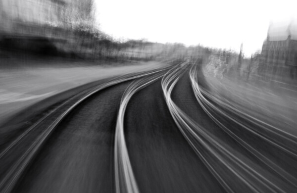 b/w photo of tram tracks, long exposure while the camera makes a twisting motion, resulting in the tracks and the horizon being weirdly distorted