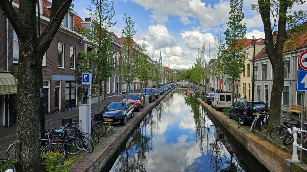 A Dutch canal street with clouds reflected in the water