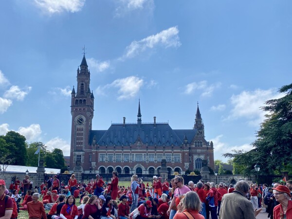 The Peace Palace in The Hague, with protestors in red before it