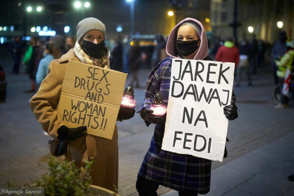 Zdjęcie z demonstracji. Dwie zamaskowane osoby pozują ze zniczami i kartonowymi tablicami z napisami. Jeden z nich to nieudolnie zfotoszopowane "SEX DRUGS AND WOMAN RIGHTS!!", drugi "JAREK DAWAJ NA FEDI".